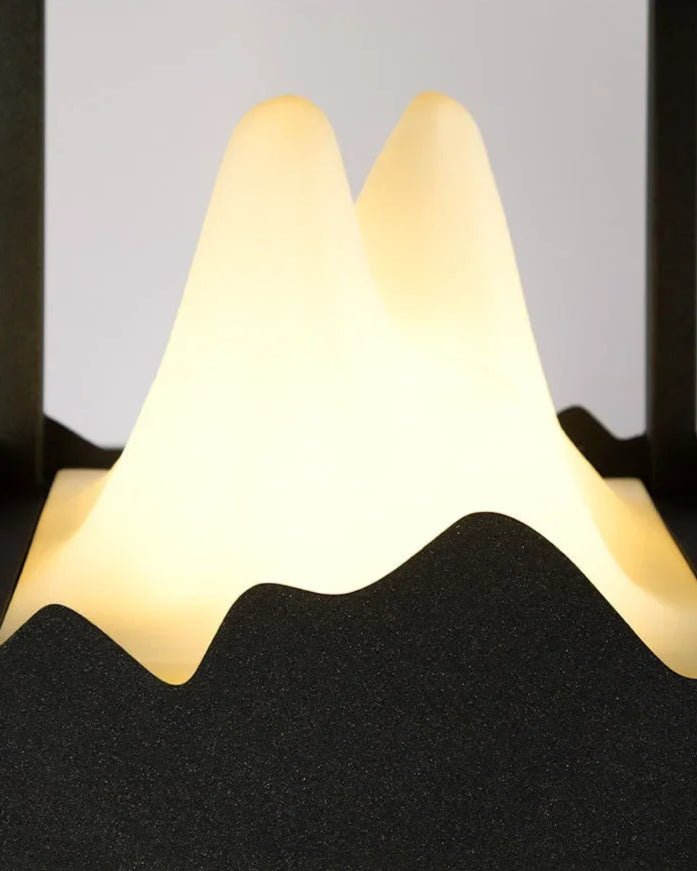 Yama Ground Light features a sculpted glass interior resembling mountain peaks with a warm, solar-powered glow.
